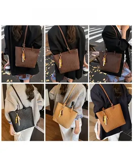 Détail de la texture tissée et du charm en perles sur le sac fourre-tout en cuir en plusieurs couleurs
