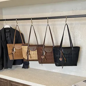 Quilted tote bags in brown and black displayed on hangers with professional styling