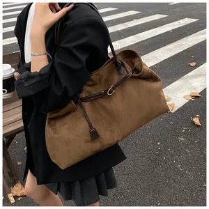 Detail view of large vintage brown suede tote bag with leather straps and gold buckle