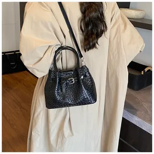 Detail of black woven texture handbag with silver metal buckle and detachable strap