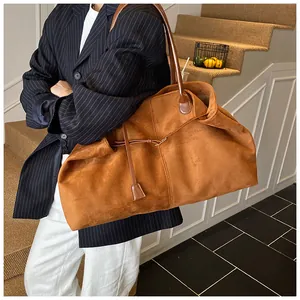 Close-up of a large brown suede tote bag with long handles and leather drawstring detail