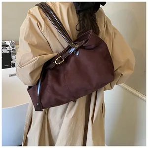 Detail of vintage large capacity tote bag with gold buckle on suede shoulder strap
