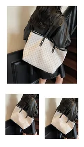 Close-up of geometric pattern tote bag featuring black leather straps and metal rivets