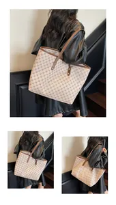 Detail of vintage monogram tote bag featuring leather straps and rivet decorations