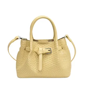 Light yellow woven textured handbag with adjustable strap for versatile shoulder or crossbody use
