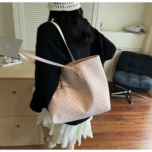 Close-up of monogram pattern tote bag with pink leather straps in a lifestyle office setting