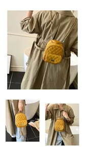 Dettaglio mini zaino trapuntato giallo con catena metallica e chiusura a girello