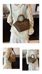 Détail du sac seau en cuir marron foncé à motif litchi avec poignée et bandoulière longue
