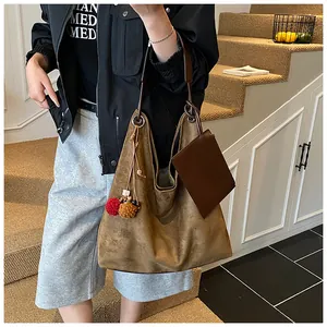 Braune Wildleder-Einkaufstasche mit Leder-Untertasche und Anhängern am Modell