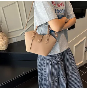 Détail du sac cabas en cuir grainé marron avec poignée, bandoulière et boucle ronde