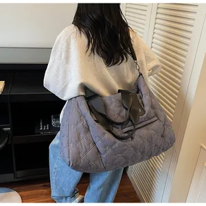 Detail of grey quilted oversized gym bag with bow embroidery and dual handles