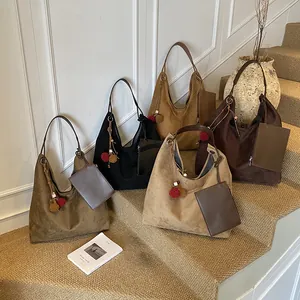 Minimalistische große Hobo-Tasche aus Wildleder in vier Erdfarben auf Treppen