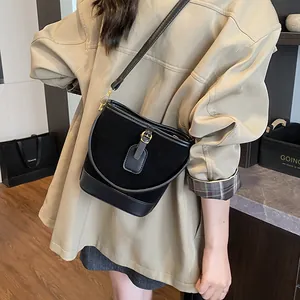 Chic black bucket bag with mixed textures shown on a model in an urban setting