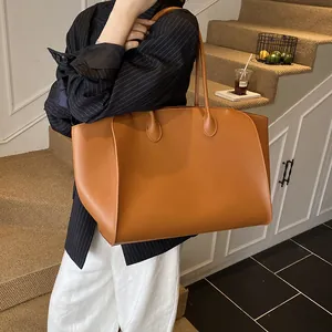 Minimalistische große Damen-Tragetasche aus karamellfarbenem Leder in einer Lifestyle-Szene