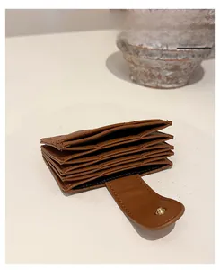 Detail of brown quilted leather card holder with multi-layer accordion design and gold snap