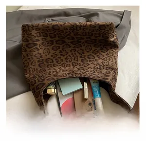 Spacious interior of leopard print tote bag holding phone, tablet and cosmetics