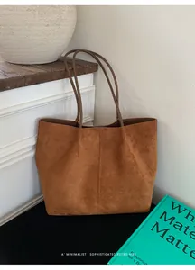 Detail of minimalist brown suede tote bag with elegant vertical stitching and retro vibe