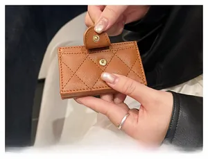 Detail of brown quilted leather card holder featuring multi-layer slots and snap button