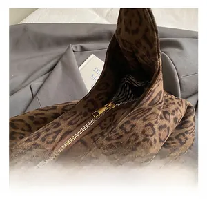Detail of leopard print tote bag showing gold metal zipper and striped lining fabric
