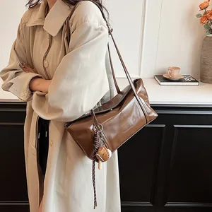 Brown glossy leather tote bag with shoulder strap and stylish food-shaped charms