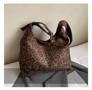 Close-up of leopard print canvas tote bag with adjustable strap and golden buckle