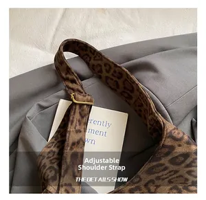 Detail of leopard print tote featuring gold adjustable strap buckle and soft velvet texture