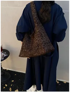 Chic leopard print tote bag styled with a long coat in a cozy cafe setting