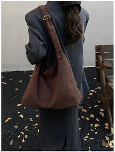 Detail of dark brown hobo shoulder bag featuring adjustable metal buckle on wide strap