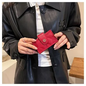 Detail of red quilted leather card holder with gold flower clasp in hand