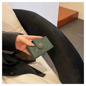 Detail of dark green quilted leather wallet with multiple card slots and floral buckle