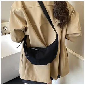 Detail of black crescent suede shoulder bag with matte texture on a casual outfit