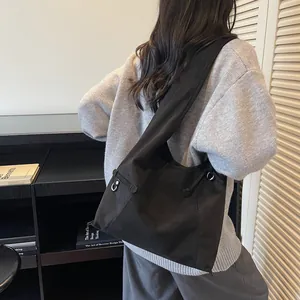 Grand sac fourre-tout noir rétro en suédine porté à l'épaule pour le trajet quotidien