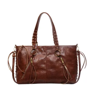 Vintage dark brown leather tote bag with tassel zippers and woven handle details