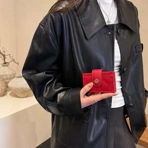 Red quilted leather wallet with gold camellia buckle shown held by a model
