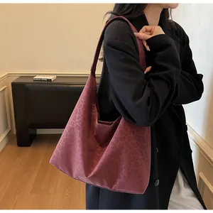 Deep pink leopard print hobo bag worn by model in a modern minimalist interior setting