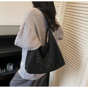 Detailed view of the matte leopard print texture on a black faux leather tote bag