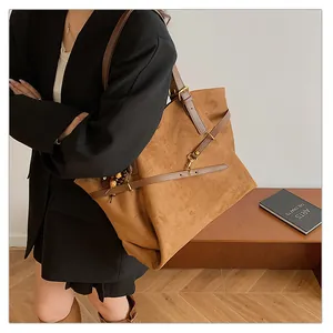 Detail shot of vintage brown suede tote bag with leather straps and gold metal buckle