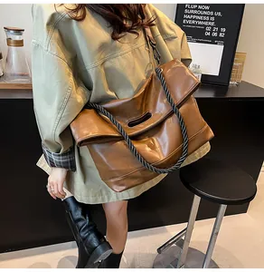 Detail view of large brown retro tote bag with unique thick rope handle and leather texture