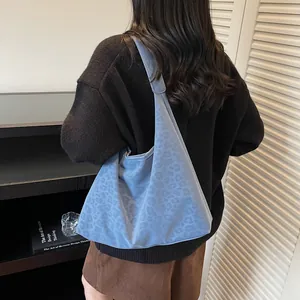 Chic light blue hobo bag with subtle leopard print and soft suede texture