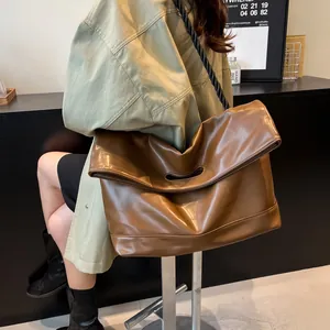 Brown large capacity leather tote bag with thick braided strap and cutout handle detail