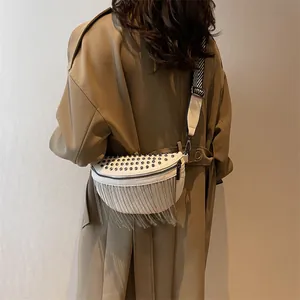 White leather fanny pack with silver studs, metal fringe and woven crossbody strap