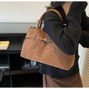 Braune Wildledertasche mit Leopardenmuster am Modell für Pendler-Stil gezeigt