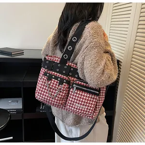 Detailed punk style red and white houndstooth bag with metal eyelets and silver rivets