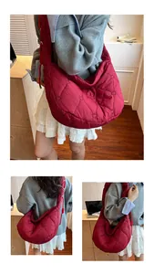 Detalle de bolso hobo acolchado burdeos con bordado de corazones y textura suave