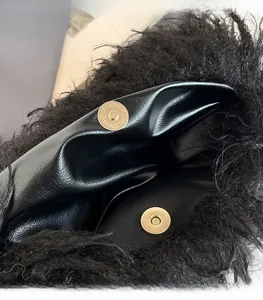 Detailed close-up of the gold magnetic closure and black faux fur texture on the handbag