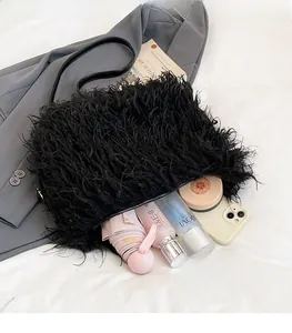 Internal capacity of black faux fur shoulder bag showing phone and cosmetics