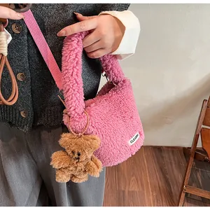 Detailed view of the pink faux fur handbag with woven strap and brown bear keychain charm
