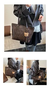 Vista dettagliata di una borsa tote in pelle vintage marrone scuro con ciondolo a orso