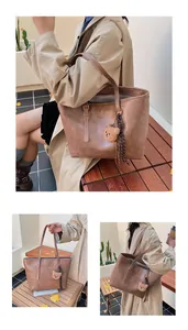 Dettaglio borsa tote vintage in pelle marrone con scritte moda e ciondolo orsetto
