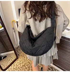 Detalle del acolchado de corazón en un bolso de nylon negro en forma de media luna